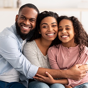 Parents and child smiling after using dental insurance in Naperville