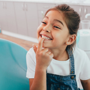 young girl pointing to teeth  