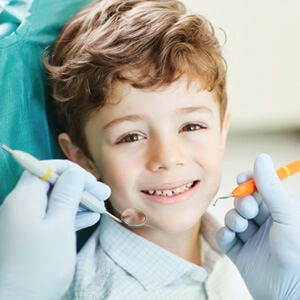 young child smiling after getting tooth colored fillings  